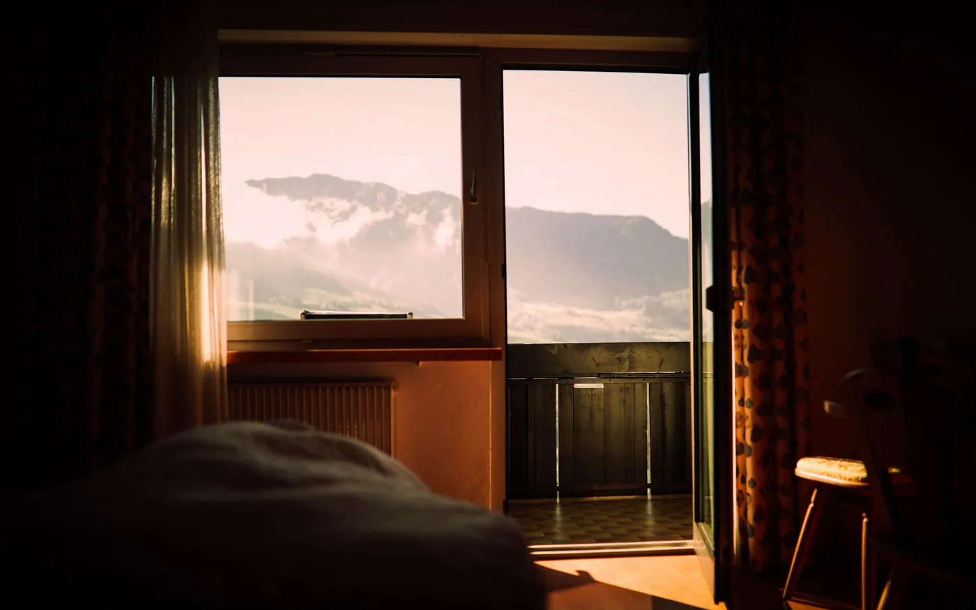 A guest room at sunset, with mountains framed by the window