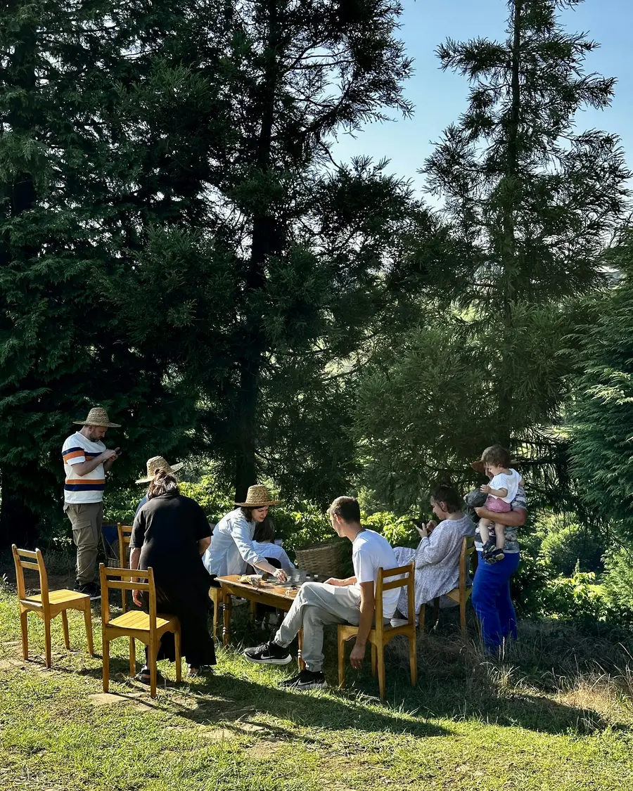 Retreat guests gathered around a long table set out under the trees