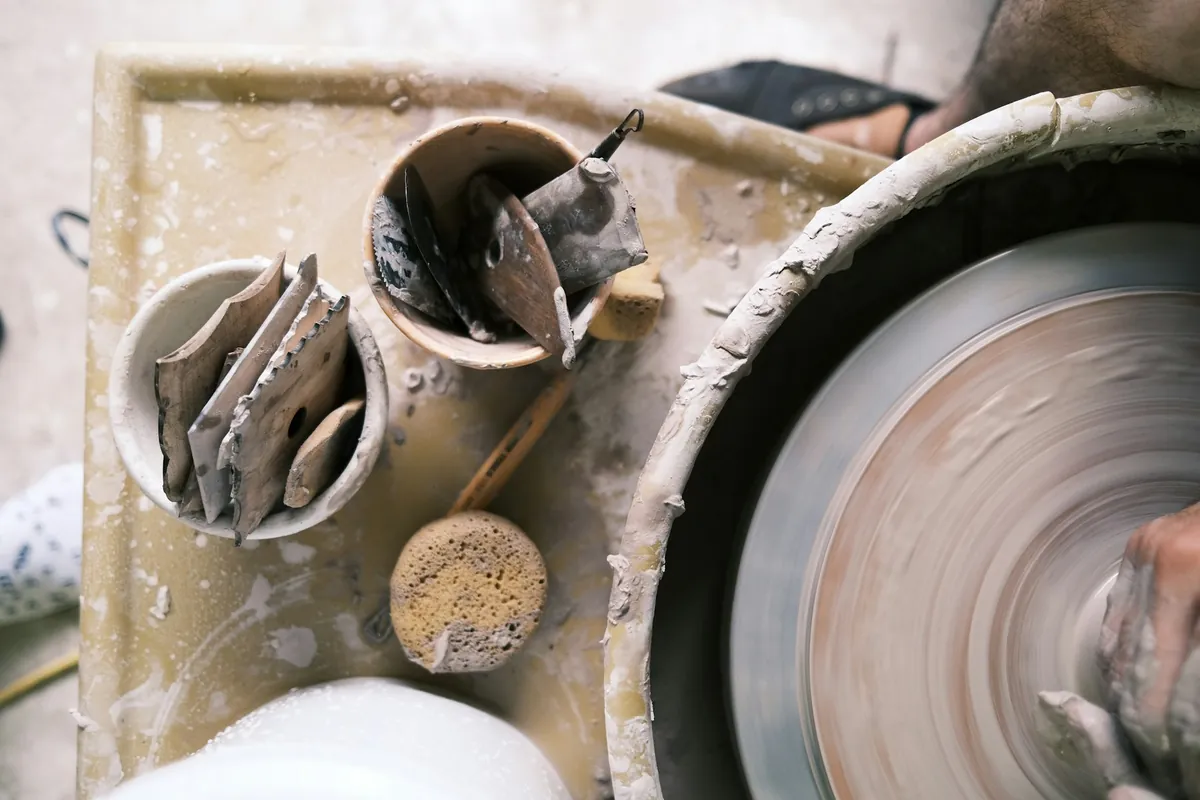 A potter's wheel and tools mid-session in a workshop